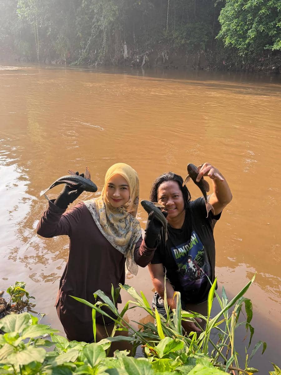 Ria Ricis menangkap ikan sapu-sapu di Sungai Ciliwung