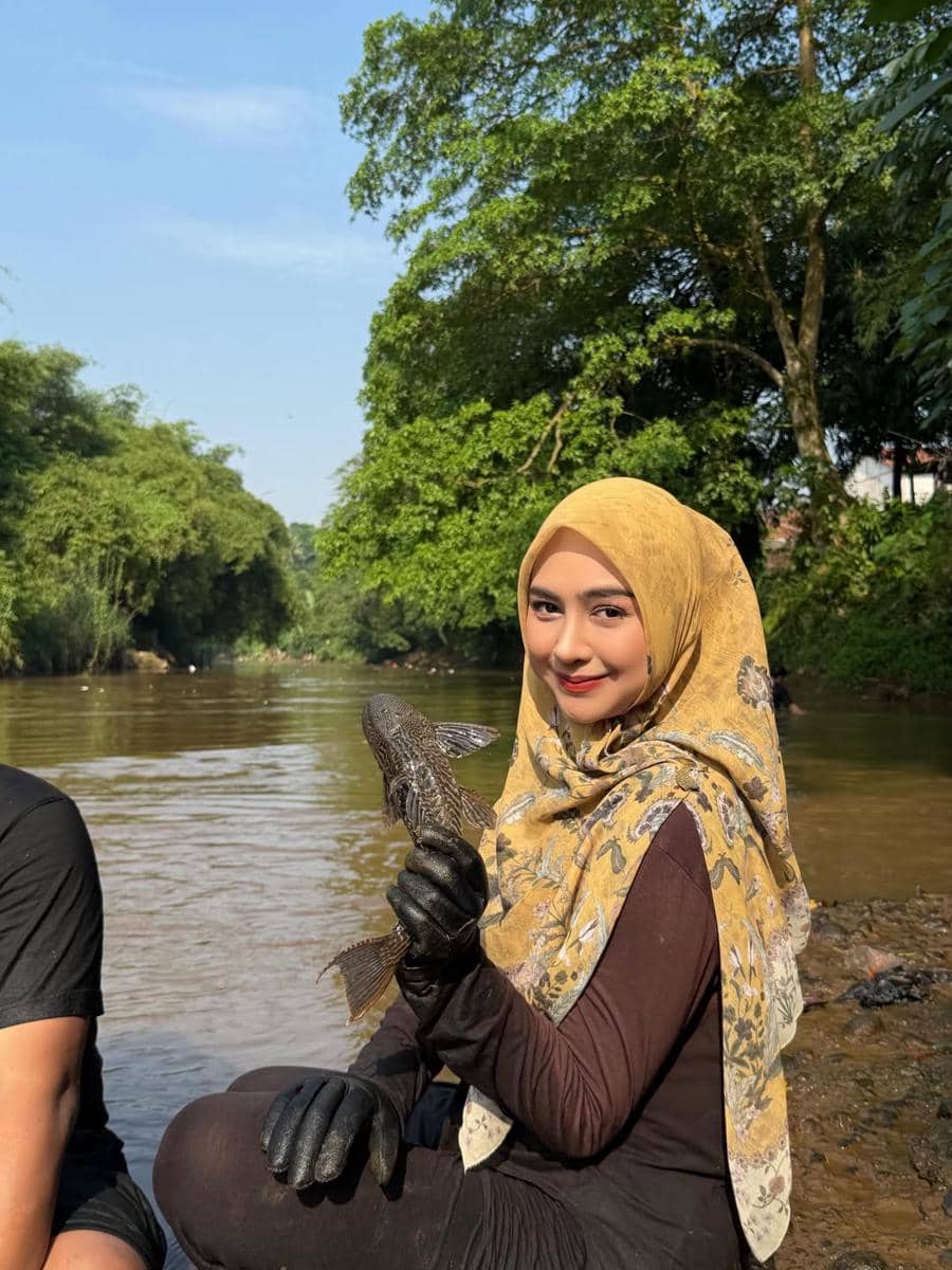 Ria Ricis menangkap ikan sapu-sapu di Sungai Ciliwung