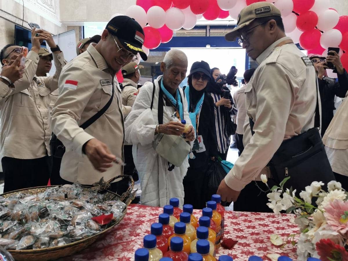 Petugas haji menyambut jemaah asal Yogyakarta di Makkah dengan hidangan minuman dan suvenir di meja berhias bunga dan balon merah putih.