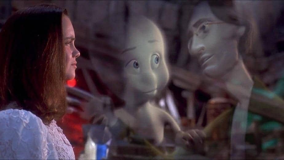 Seorang gadis muda menatap hantu ramah Casper yang tampak transparan bersama sosok pria di latar dalam adegan film fantasi.