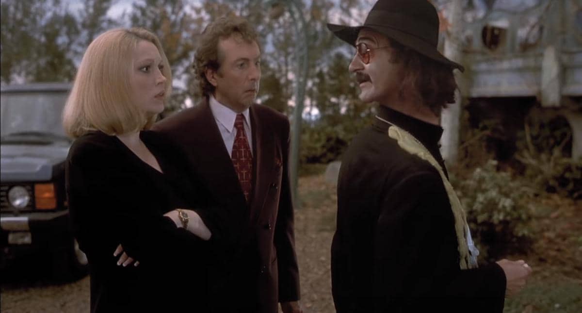 Tiga karakter berdiri di luar ruangan, dua mengenakan pakaian formal dan satu memakai topi hitam serta kacamata, dalam adegan film Casper.