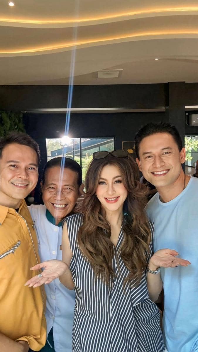 Empat orang tersenyum berpose bersama di dalam ruangan dengan pencahayaan hangat, tampak akrab dan ceria saat berfoto.