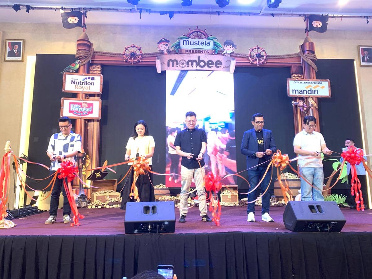 Beberapa orang memotong pita saat pembukaan Mombee Expo 2026 di Medan dengan latar panggung bertema anak dan sponsor acara.