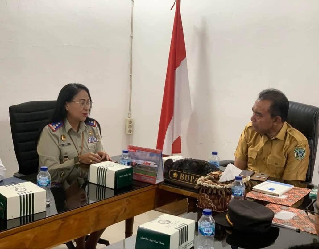 Bupati Flores Timur berbincang dengan perwakilan Kantor Pertahanan Flores Timur di ruang rapat dengan latar bendera Indonesia.