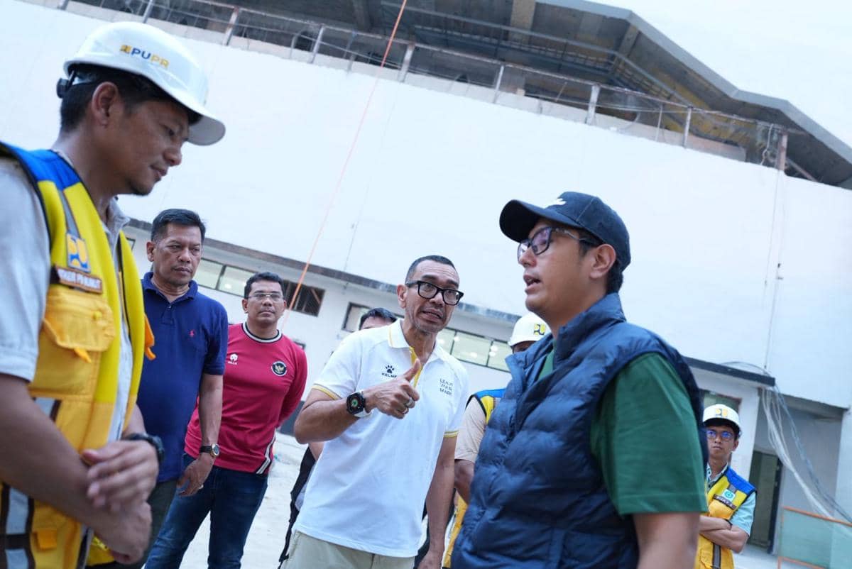 Beberapa orang termasuk petugas berseragam PU dan pejabat daerah meninjau pembangunan Stadion Teladan Medan menjelang AFF U-19.