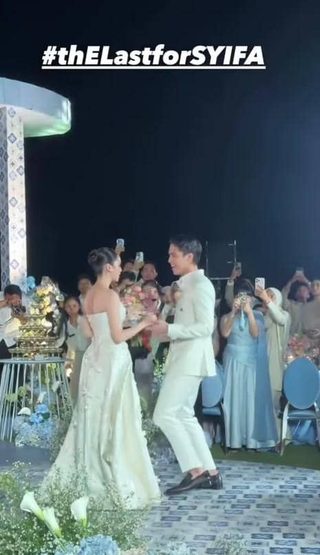 Pasangan pengantin mengenakan busana putih menari di resepsi pernikahan mewah di Bali dengan tamu yang mengabadikan momen tersebut.