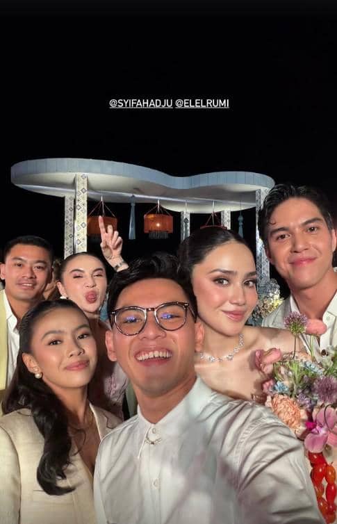 Sekelompok artis berpose bersama dalam suasana malam di resepsi pernikahan di Bali dengan latar dekorasi elegan dan pencahayaan hangat.
