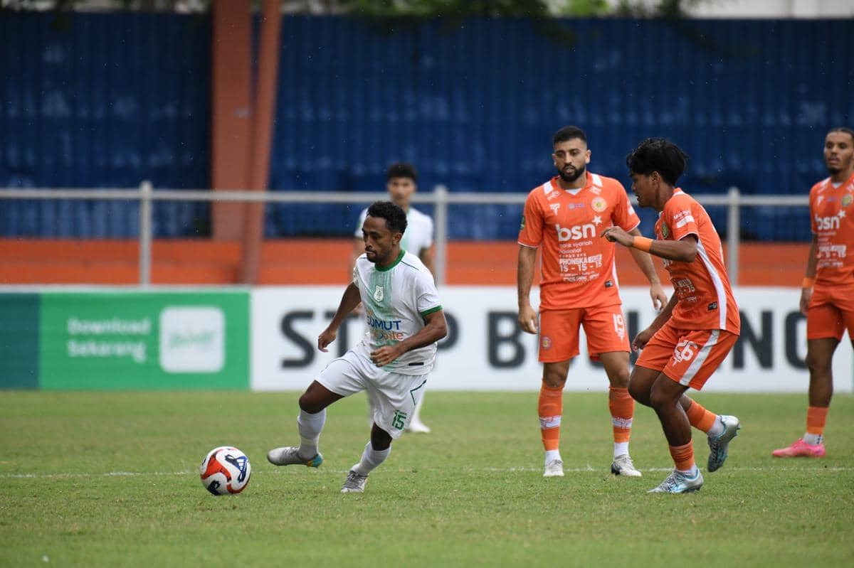 Pemain PSMS mengenakan seragam putih menggiring bola menghadapi pemain Persiraja berseragam oranye pada laga di Stadion H Dimurthala.