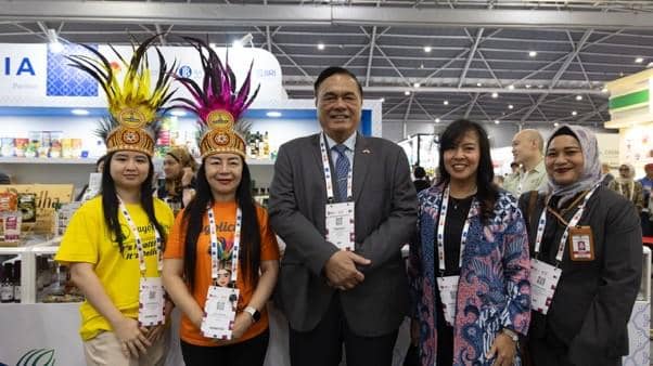 Perwakilan UMKM BRI berfoto bersama di ajang Food and Hospitality Asia 2026 di Singapura dengan latar stan pameran produk.