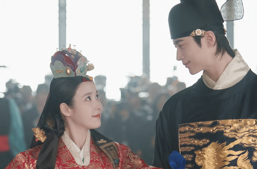 Dua aktor mengenakan hanbok kerajaan tradisional Korea saling menatap dalam adegan drama sejarah Perfect Crown.