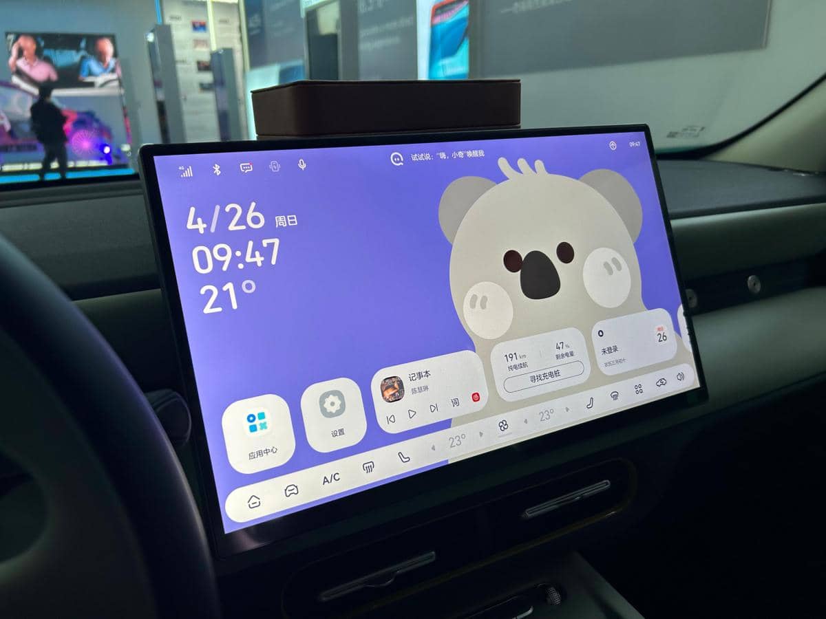 Layar head unit besar pada mobil Chery Q menampilkan antarmuka digital berwarna ungu dengan ilustrasi koala di bagian tengah.