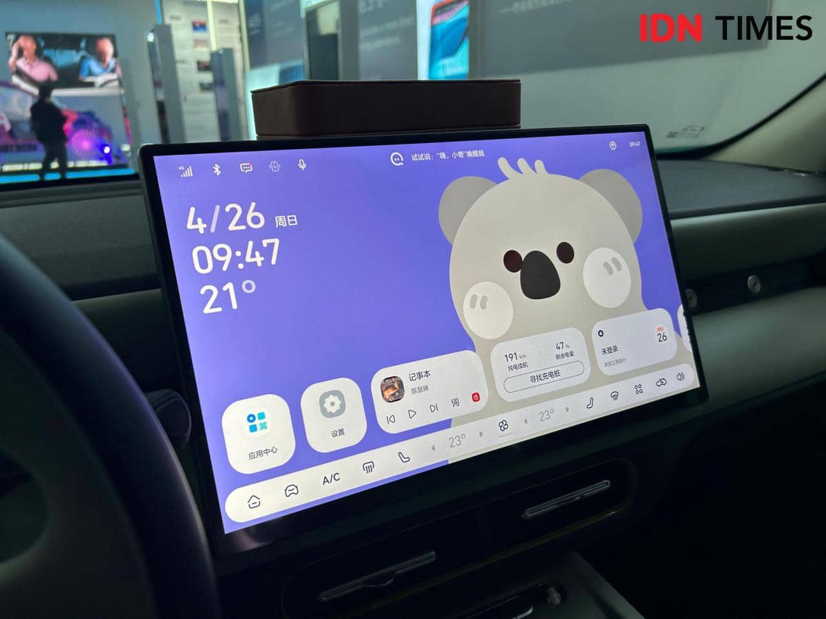 Layar head unit besar pada mobil Chery Q menampilkan antarmuka digital berwarna ungu dengan ilustrasi koala di bagian tengah.
