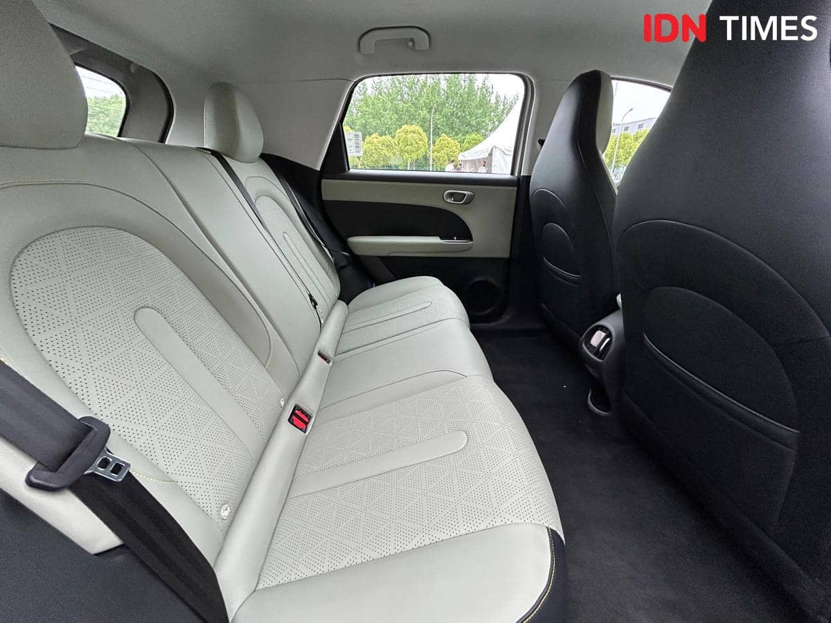 Jok baris kedua mobil Chery Q berwarna terang dengan desain modern dan ruang kaki yang lega di bagian interior belakang.