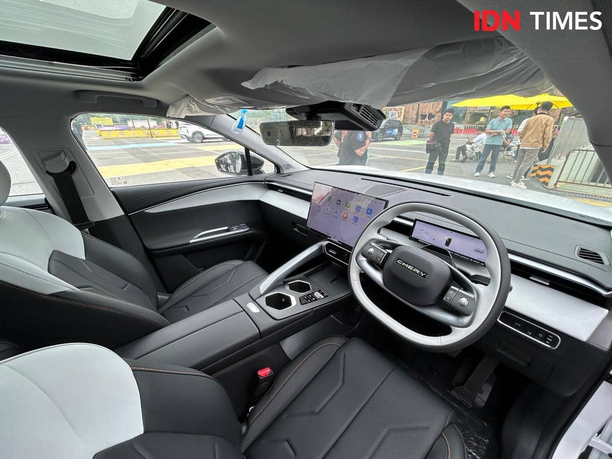 Interior mobil Chery dengan desain modern dan minimalis, dilengkapi layar digital lebar, jok kulit hitam, dan atap panoramik kaca.