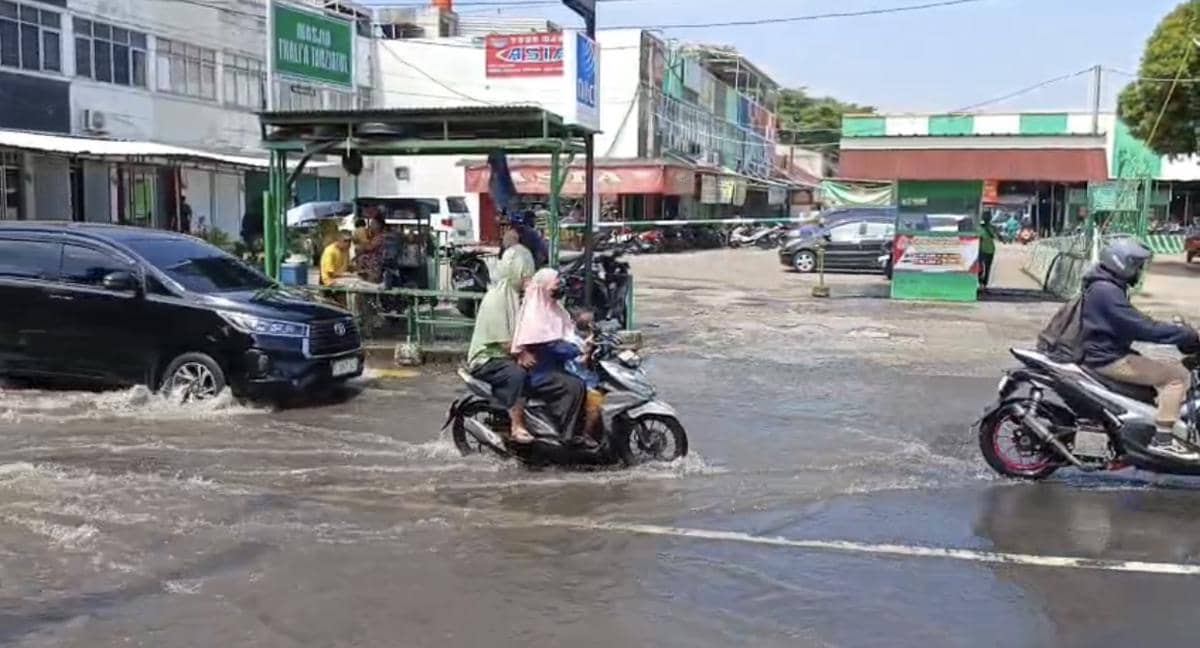Kendaraan bermotor melintasi jalan yang tergenang air di sekitar Perumahan Taman Mangu Indah akibat luapan Kali Ciputat.