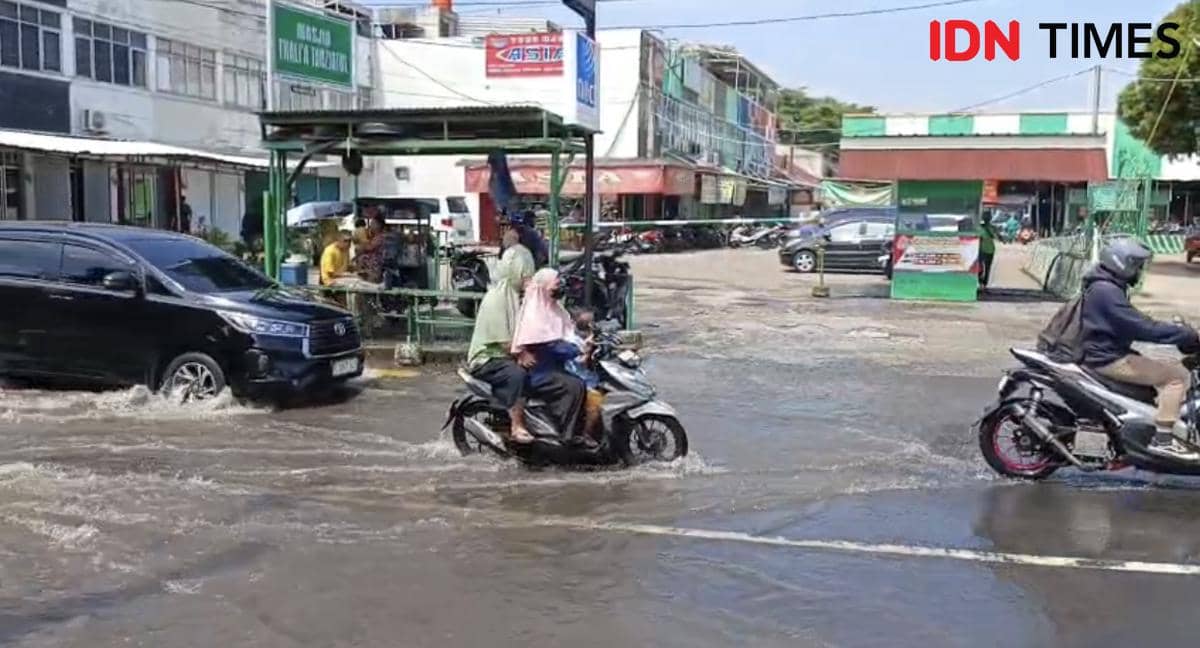 Kendaraan bermotor melintasi jalan yang tergenang air di sekitar Perumahan Taman Mangu Indah akibat luapan Kali Ciputat.