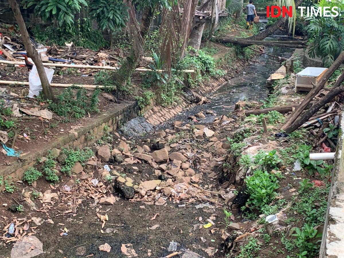 Kondisi aliran Kali Ciputat kecil yang kering dan dipenuhi sampah dengan lingkungan sekitar yang tampak tidak terawat.