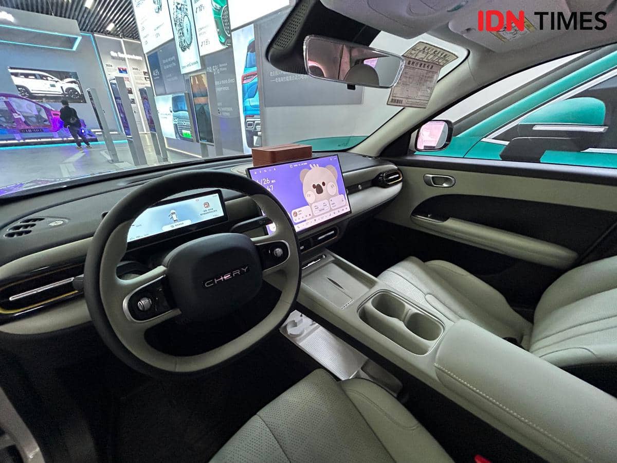 Interior mobil Chery Q dengan desain modern, layar digital besar di dashboard, dan jok kulit berwarna terang yang elegan.