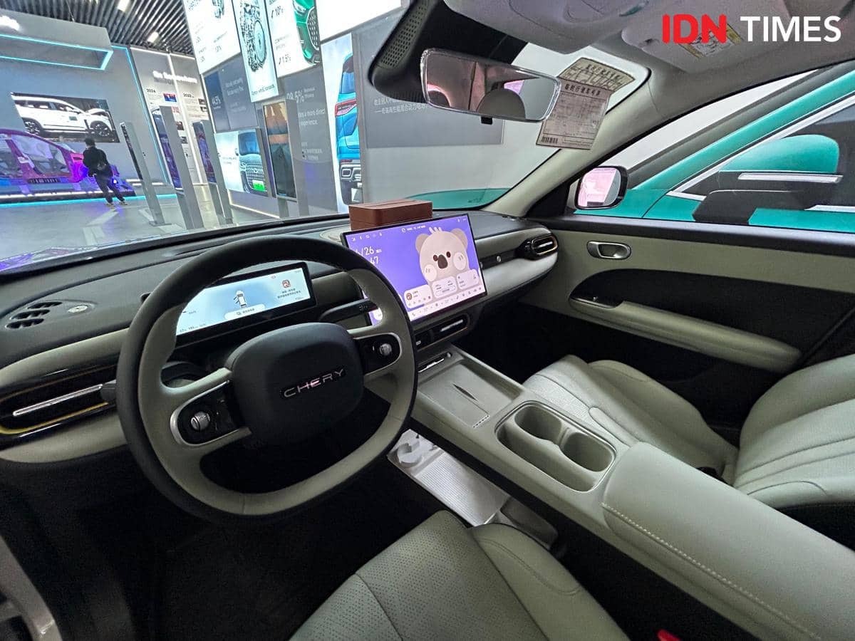 Interior mobil Chery Q dengan desain modern, layar digital besar di dashboard, dan jok kulit berwarna terang yang elegan.
