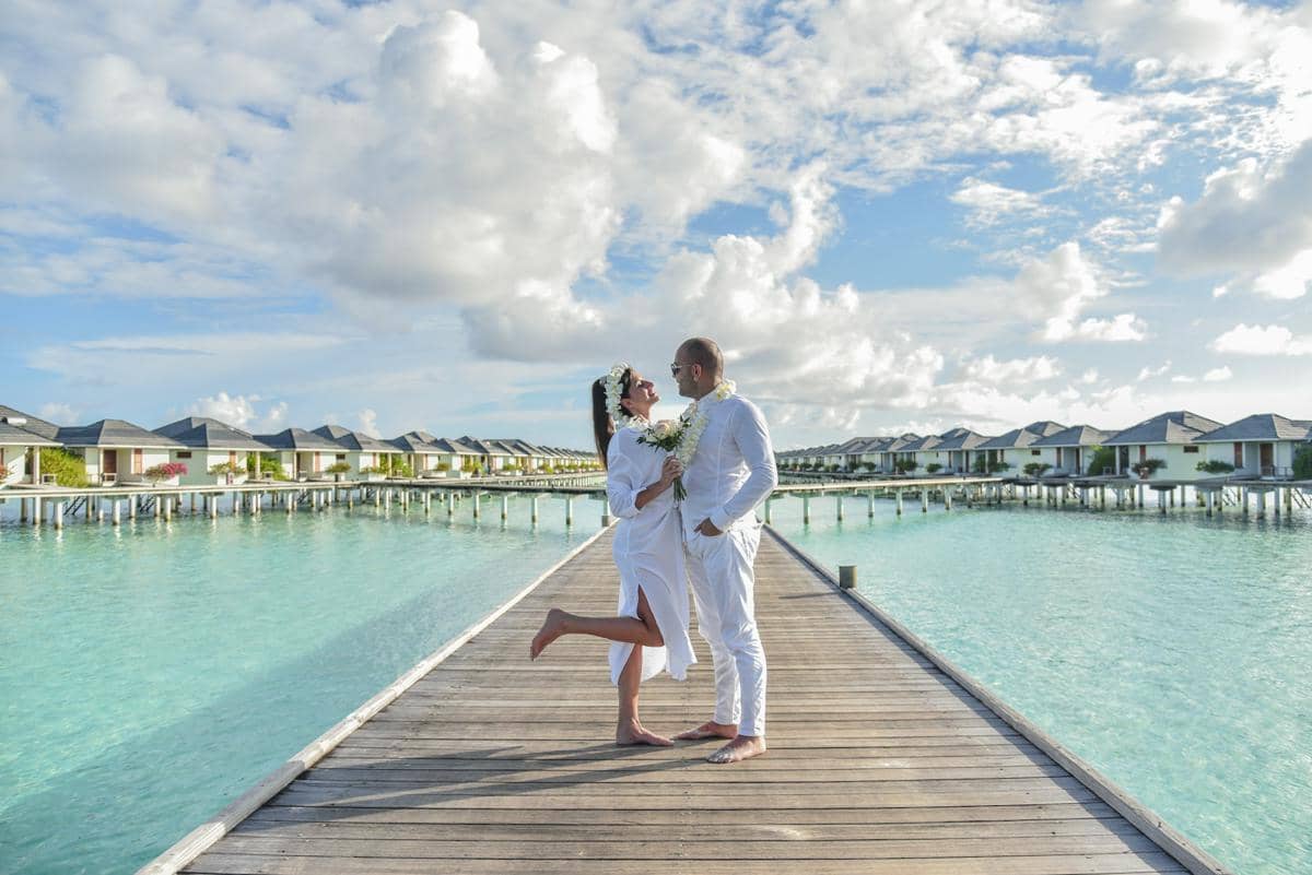 ilustrasi pasangan berswafoto di overwater villa