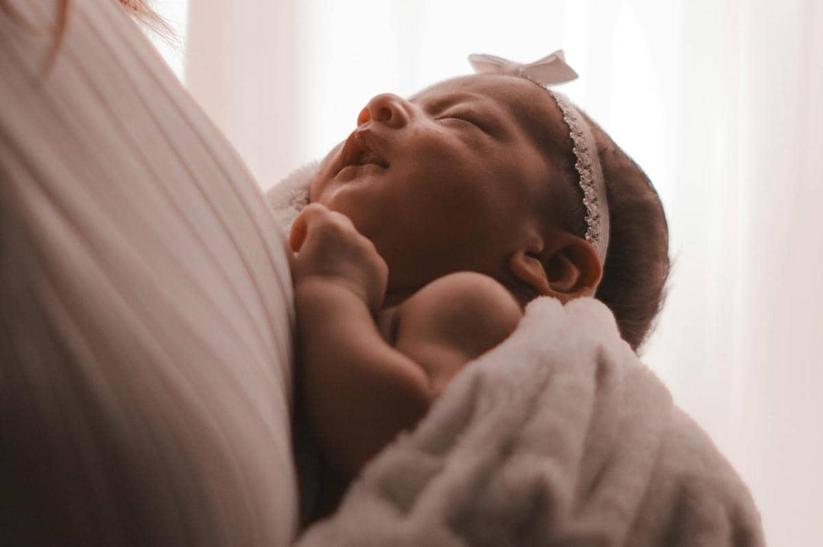 bayi yang tertidur di dekapan ibunya