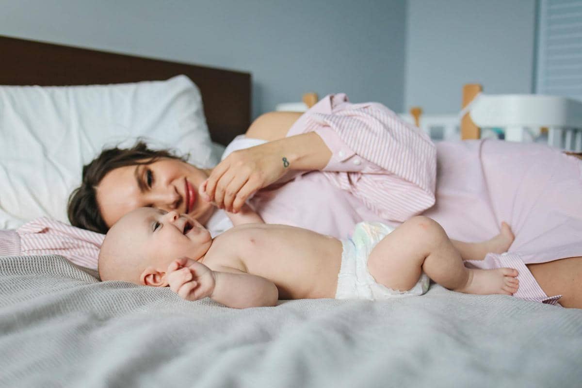 ibu dan anak yang sedang berbaring di kasur