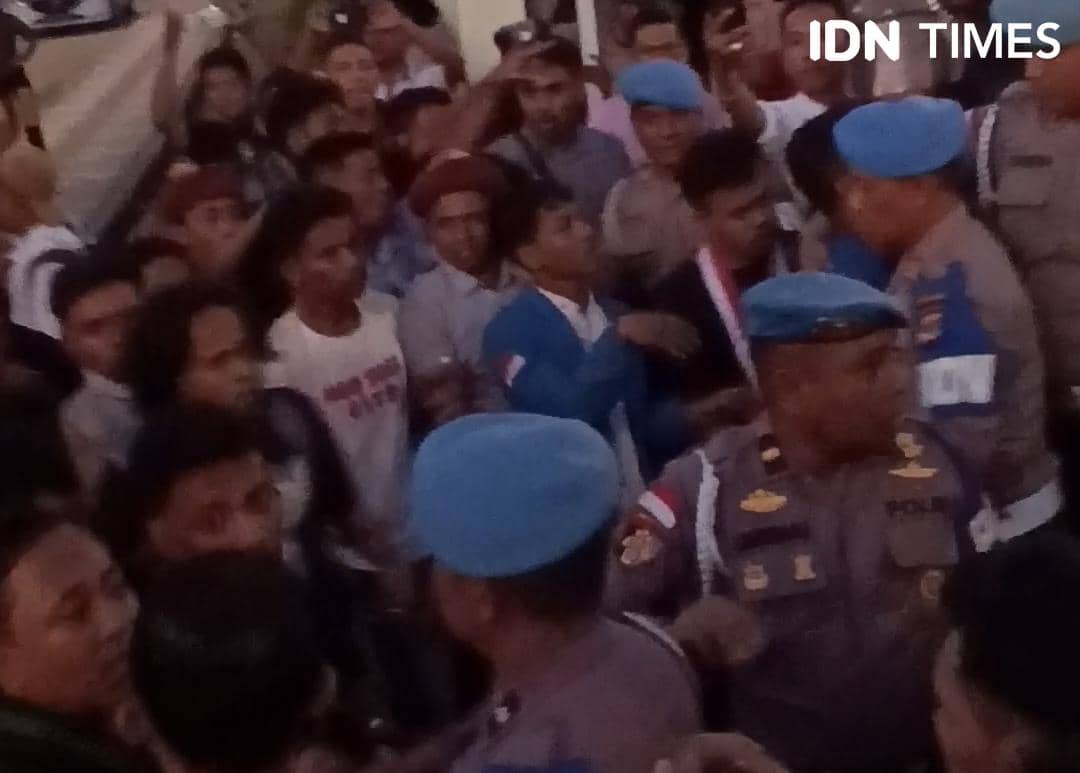 Polisi dengan seragam dan baret biru mengamankan kerumunan massa dalam aksi demonstrasi Hari Buruh dan Hari Pendidikan Nasional di Kupang.