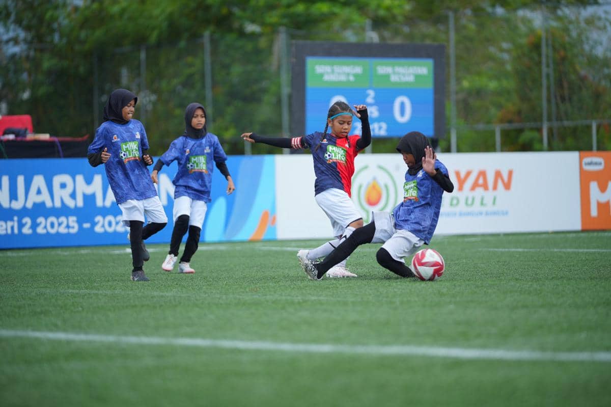 Anak-anak perempuan bermain sepak bola di turnamen MLSC Banjarmasin Seri 2 2025-2026 dengan semangat di lapangan hijau.