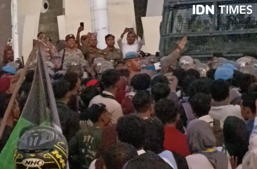 Kerumunan massa dan polisi berhadapan saat aksi demo memperingati Hari Buruh dan Hari Pendidikan Nasional di Kupang.