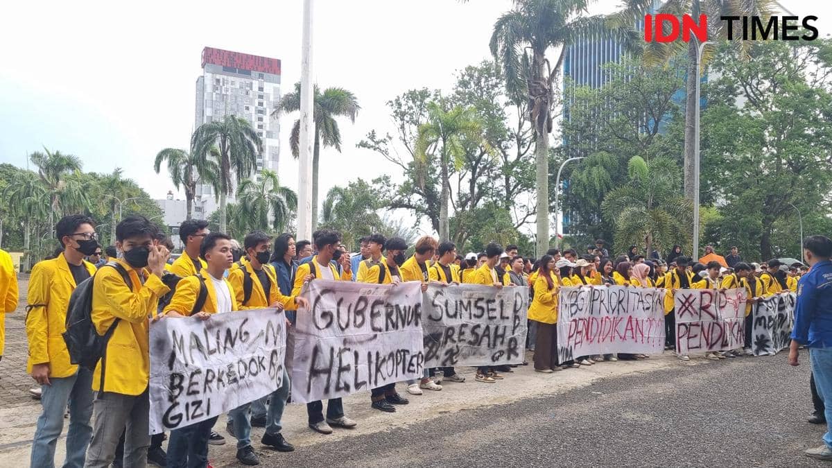 Mahasiswa mengenakan jaket almamater kuning berunjuk rasa di depan Kantor DPRD Sumsel membawa spanduk berisi kritik terhadap infrastruktur dan pendidikan.