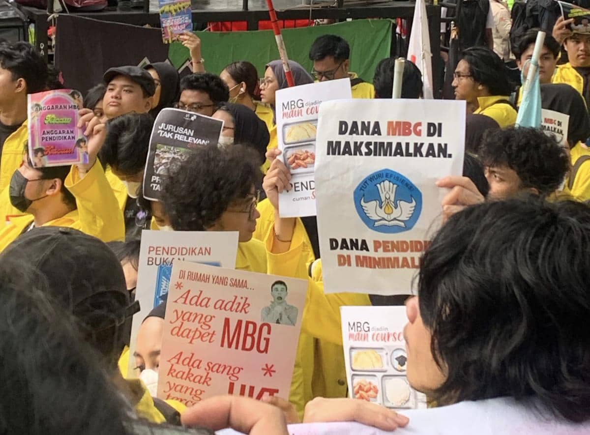 Mahasiswa BEM UI mengenakan jaket kuning membawa poster tuntutan saat melakukan demonstrasi di depan Kemendikdasmen pada awal Mei 2026.
