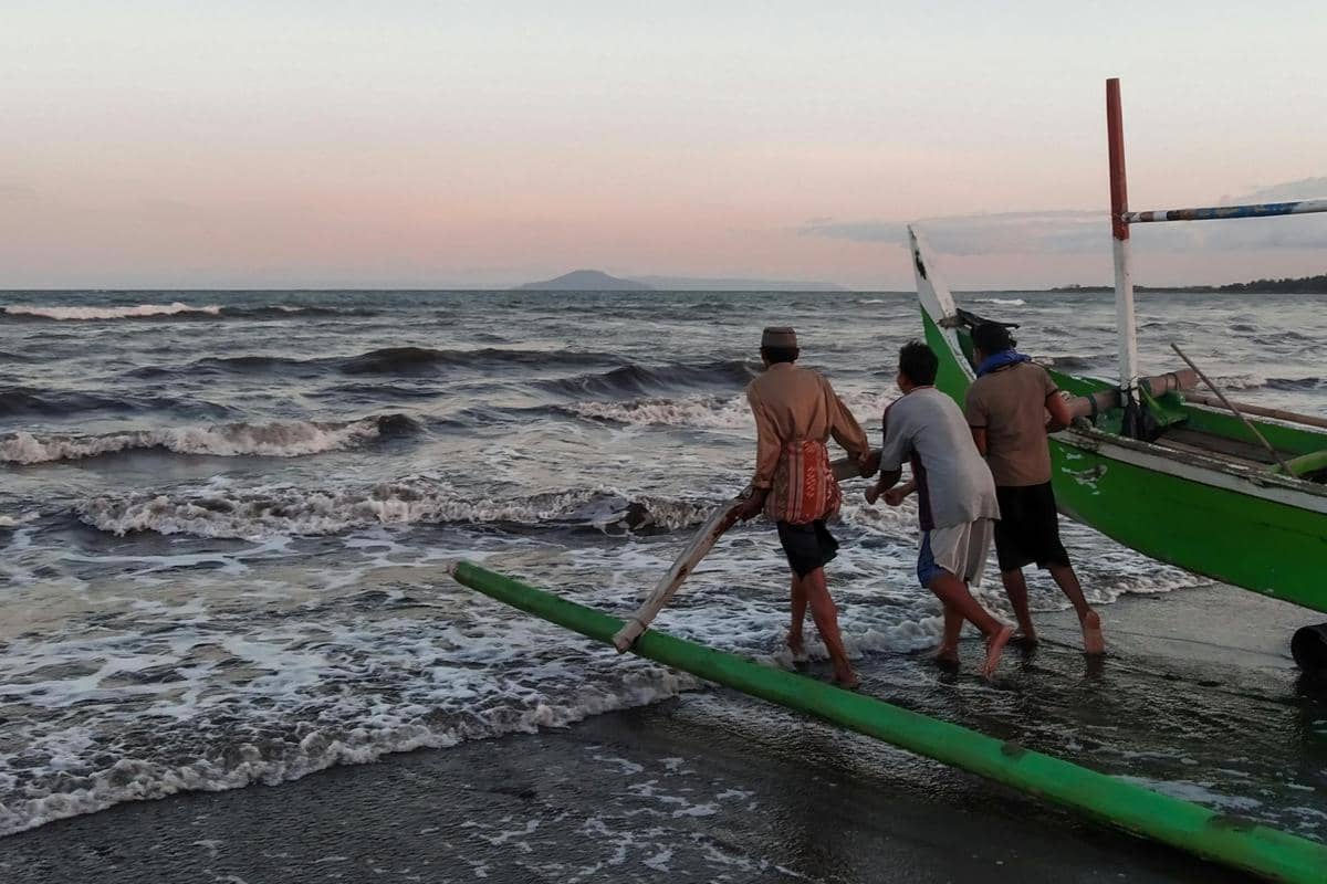 Ilustrasi pantai dengan suasana santai dan perahu nelayan.