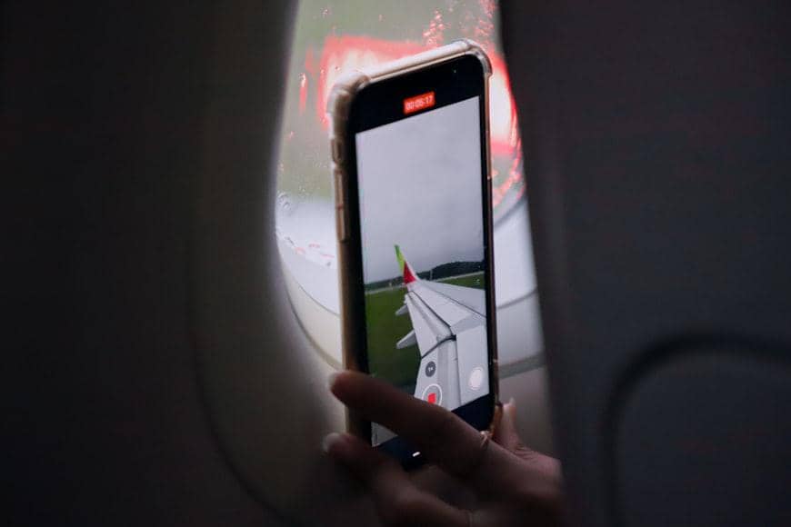 ilustrasi seseorang yang menggunakan smartphone di pesawat