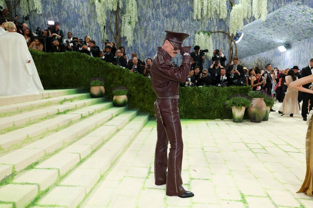 Luke Evans mengenakan pakaian kulit berwarna cokelat gelap dengan topi serasi berpose di tangga acara Met Gala 2026 yang dipenuhi fotografer.