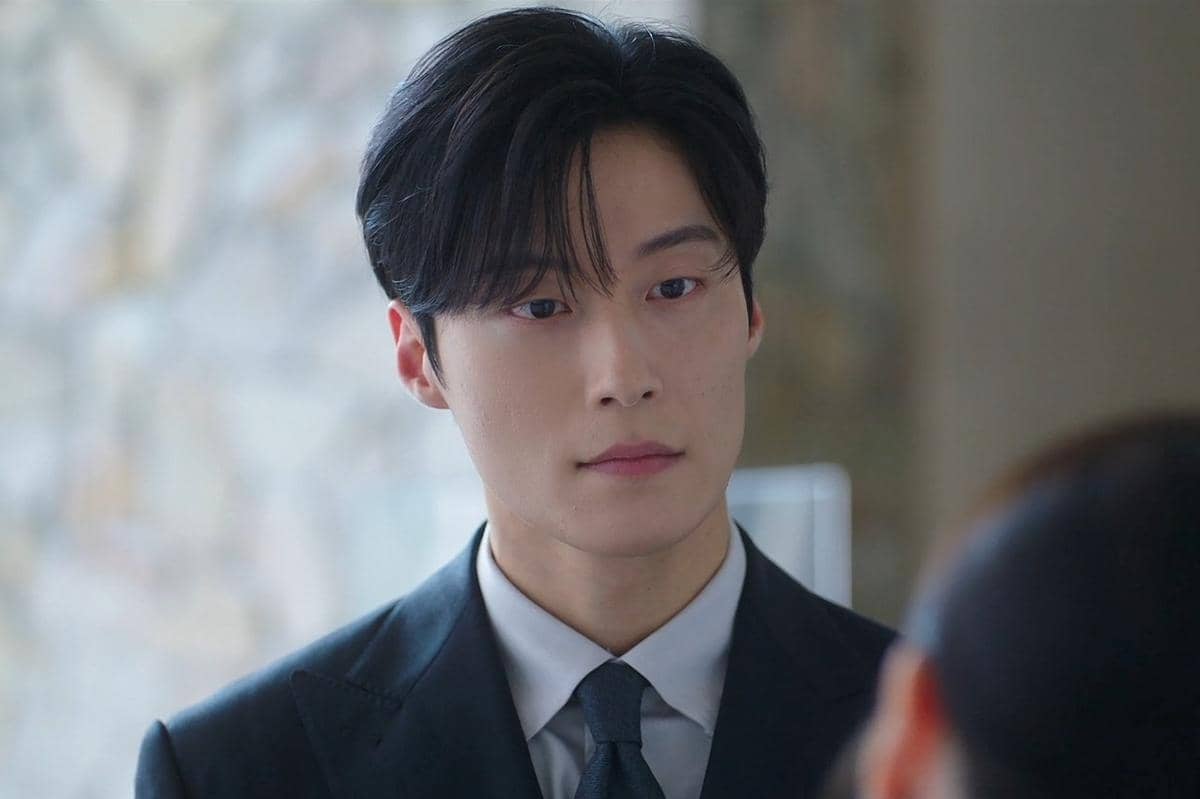 Seorang pria berjas hitam dengan ekspresi serius dalam adegan drama Korea Perfect Crown di Disney+ Hotstar.