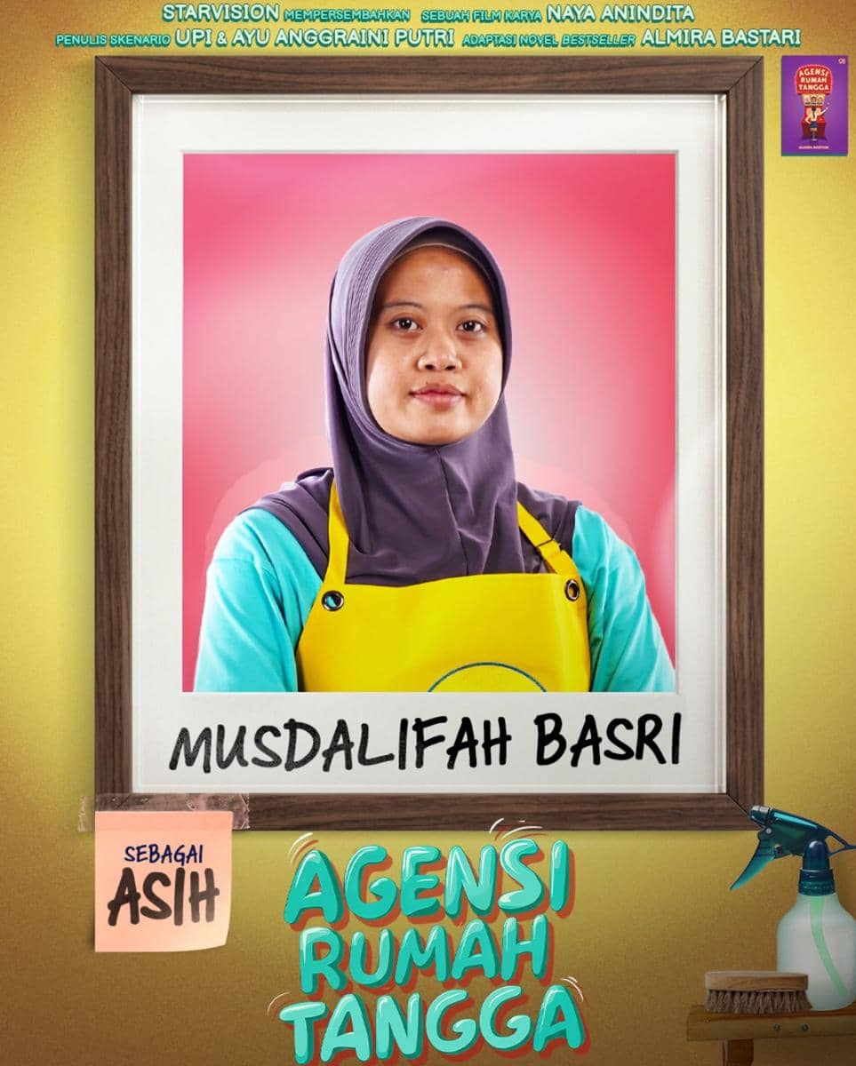 Seorang perempuan berhijab mengenakan celemek kuning berpose di depan latar merah muda dalam poster film Agensi Rumah Tangga.