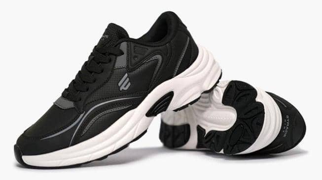 Sepasang sepatu sneakers hitam dengan sol tebal berwarna putih, menampilkan desain sporty dan modern di atas latar putih.
