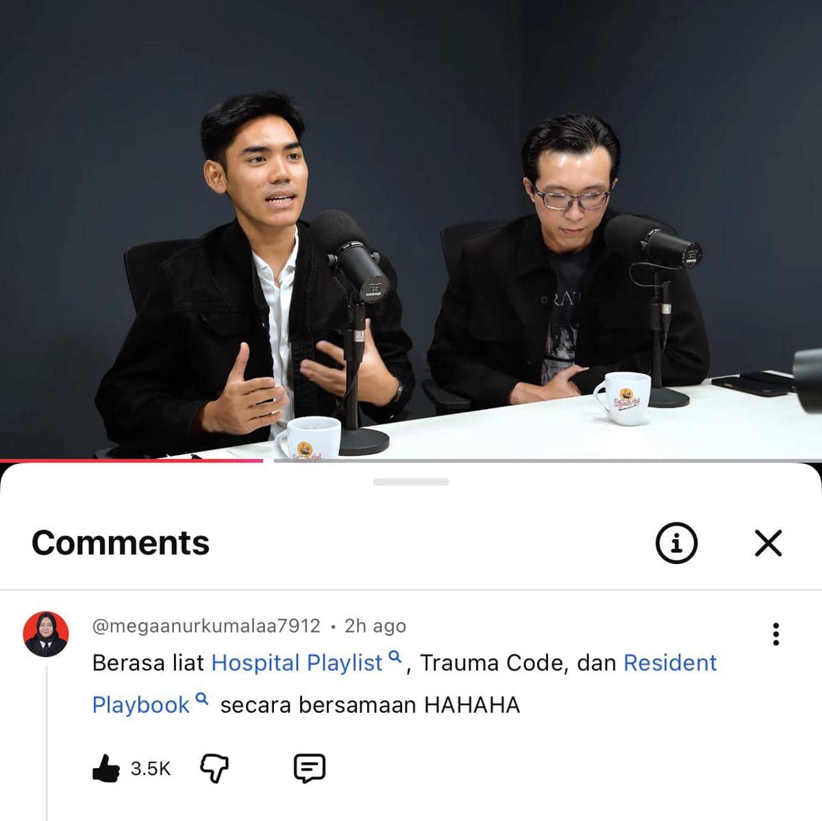 Dua pria berbicara di depan mikrofon dalam studio podcast dengan latar gelap, disertai tangkapan layar komentar lucu dari YouTube di bagian bawah.