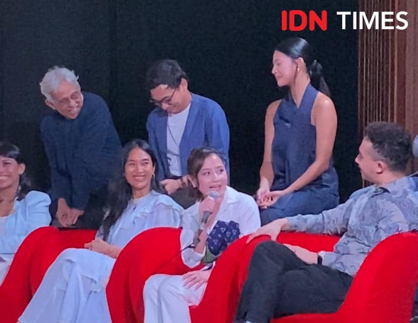 Beberapa orang duduk di kursi merah saat konferensi pers Next Step Studio Indonesia, dengan salah satu pembicara memegang mikrofon.