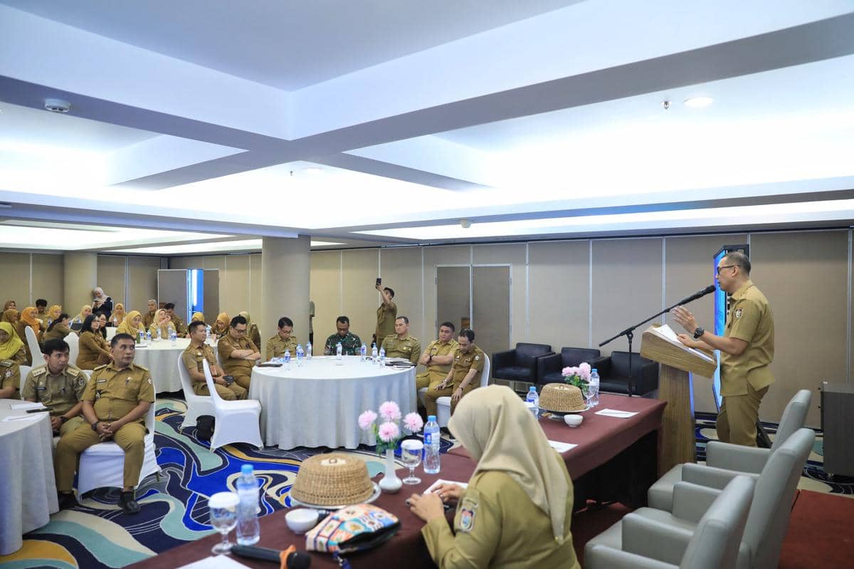 Seorang pejabat berbicara di podium dalam pertemuan koordinasi penanganan ODGJ di Hotel Aston Makassar, dihadiri peserta berseragam dinas.