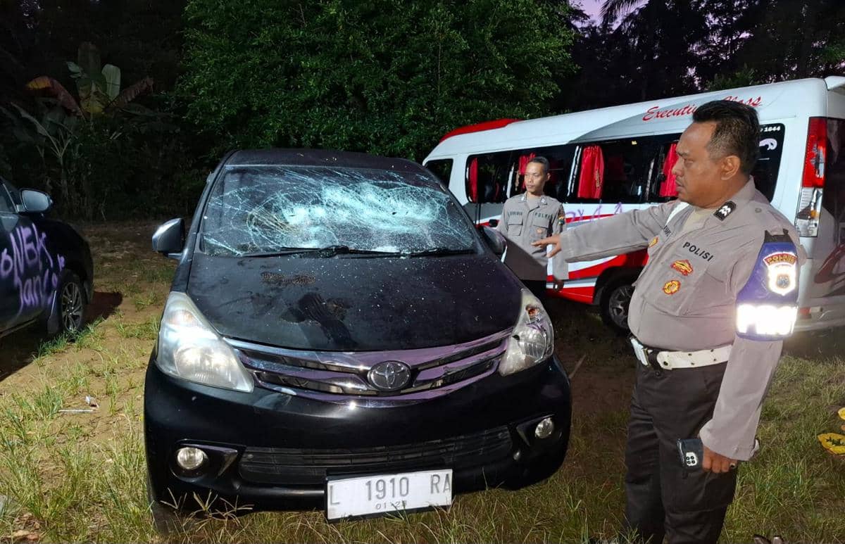 Petugas polisi memeriksa mobil wisatawan asal Surabaya yang rusak dengan kaca depan pecah di area Pantai Wedi Awu, Malang.