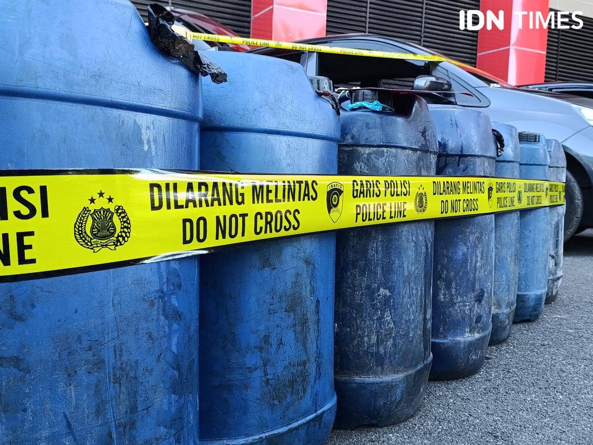 Deretan jeriken biru berisi BBM disegel dengan garis polisi bertuliskan 'Dilarang Melintas' di area Polda NTT.