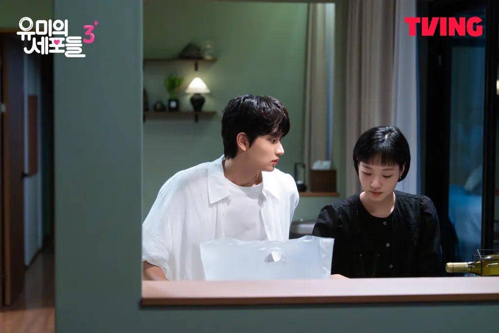 Dua karakter sedang berbincang di dapur dalam adegan drama Yumi's Cells 3, dengan suasana hangat dan pencahayaan lembut.