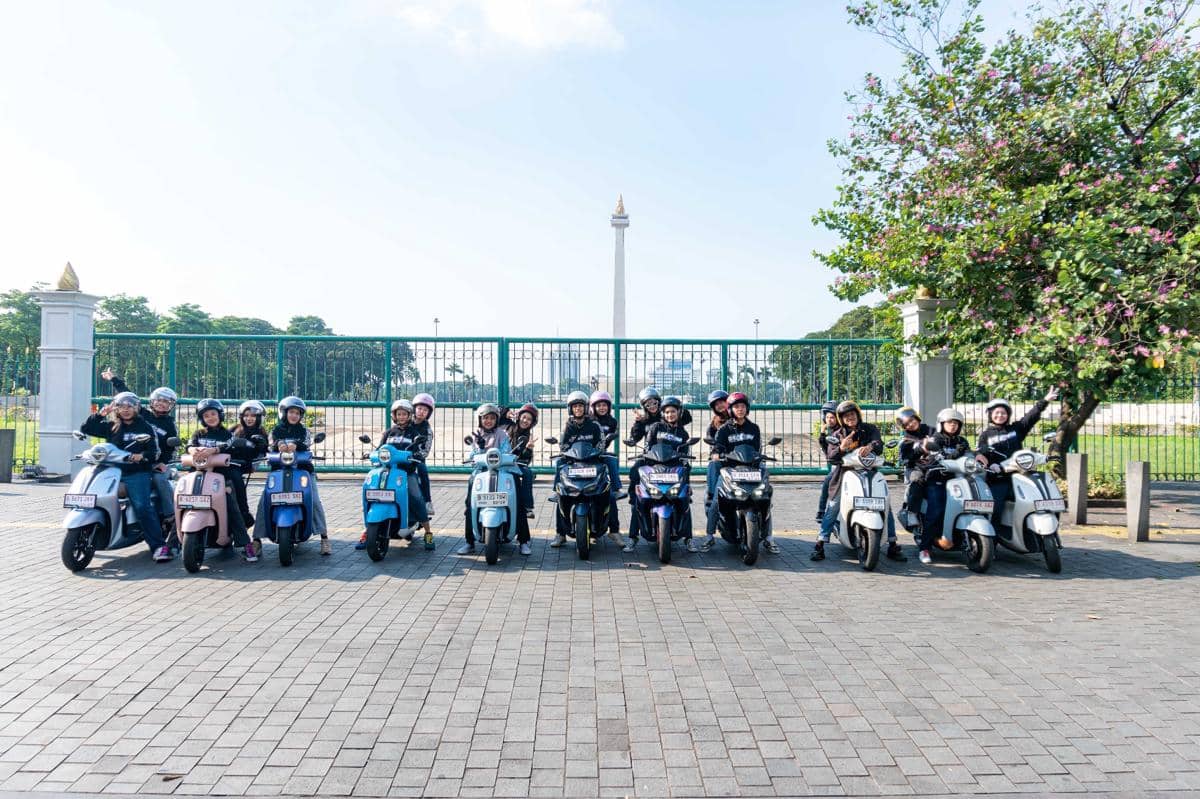 Sekelompok remaja mengendarai skuter Yamaha berbaris di depan Monas Jakarta sambil mengenakan helm dan jaket hitam.