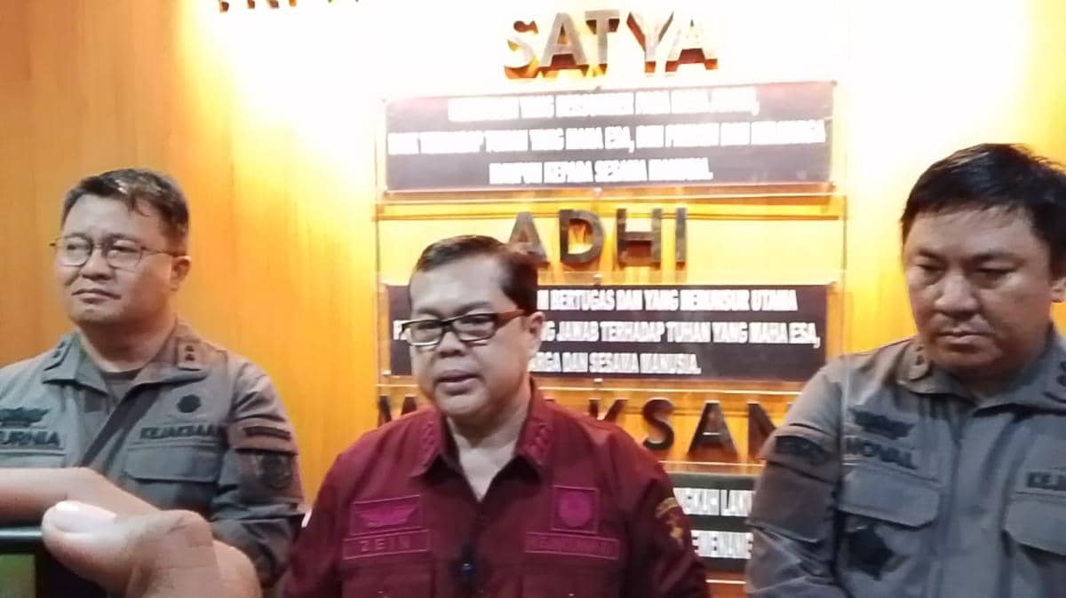 Tiga pejabat Kejaksaan mengenakan seragam dinas berdiri di depan latar bertuliskan ADHYAKSA saat konferensi pers di kantor Kejati Sulut.