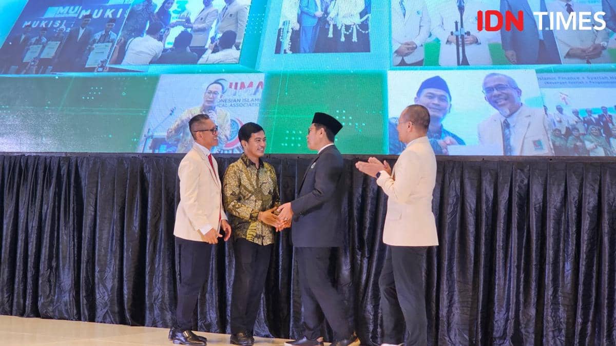 Beberapa pria berpakaian formal berjabat tangan di atas panggung acara di Tangerang dengan latar layar besar menampilkan foto kegiatan.