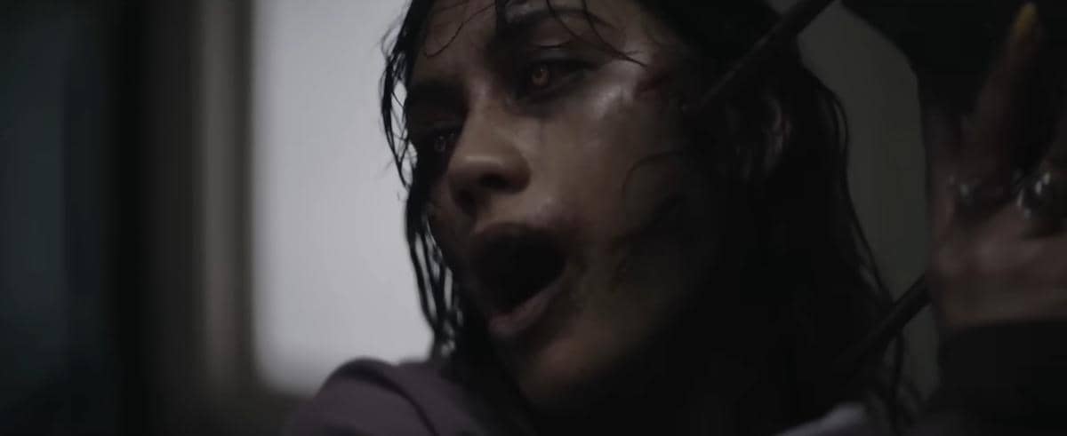 Seorang wanita dengan wajah berdarah dan mata menyeramkan dalam adegan menegangkan dari trailer film horor Evil Dead Burn.