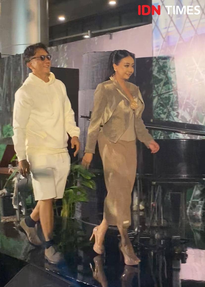 Dua pemain film berjalan di atas panggung saat gala premier film Semua Akan Baik-Baik Saja pada Rabu malam, mengenakan busana elegan.