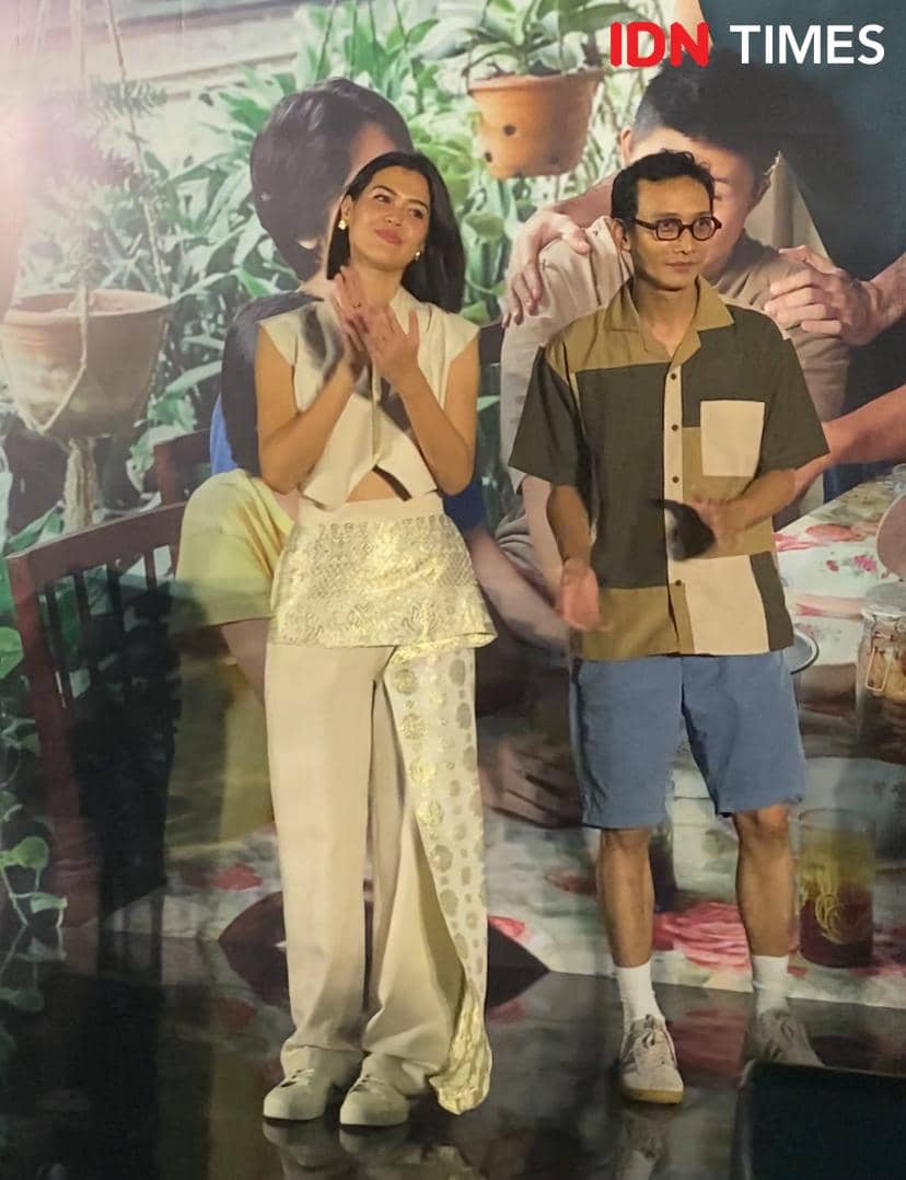 Dua pemain berdiri berdampingan di acara gala premier film Semua Akan Baik-Baik Saja, mengenakan busana kasual dan elegan.
