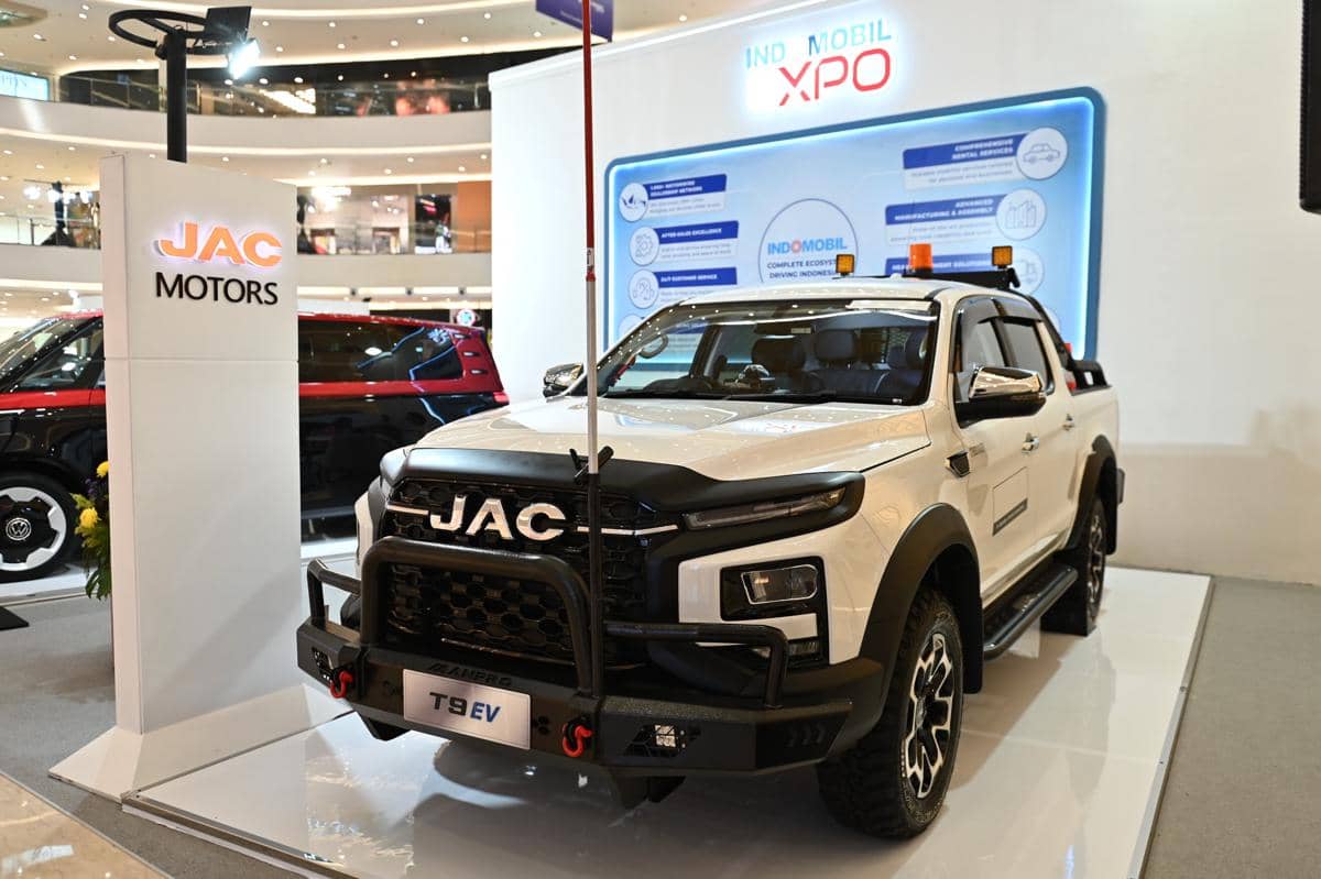 Mobil listrik JAC T9 EV berwarna putih dipamerkan di stan JAC Motors dalam acara Indomobil XPO di pusat perbelanjaan.